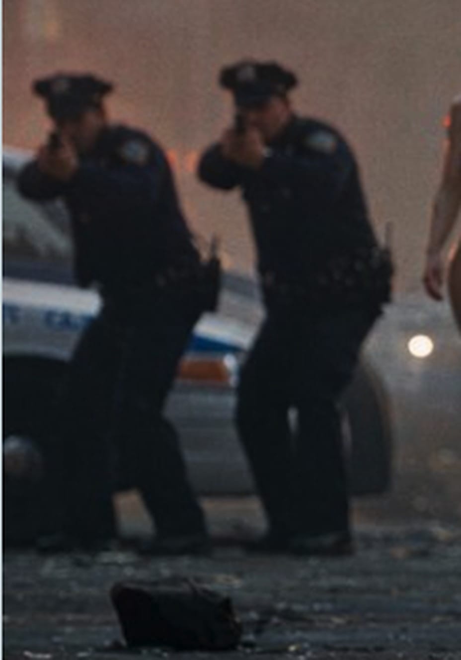 Deux policiers du NYPD en position de tir dans la brume, devant une voiture de patrouille, plan extrait de la bande annonce Goonpocalypse