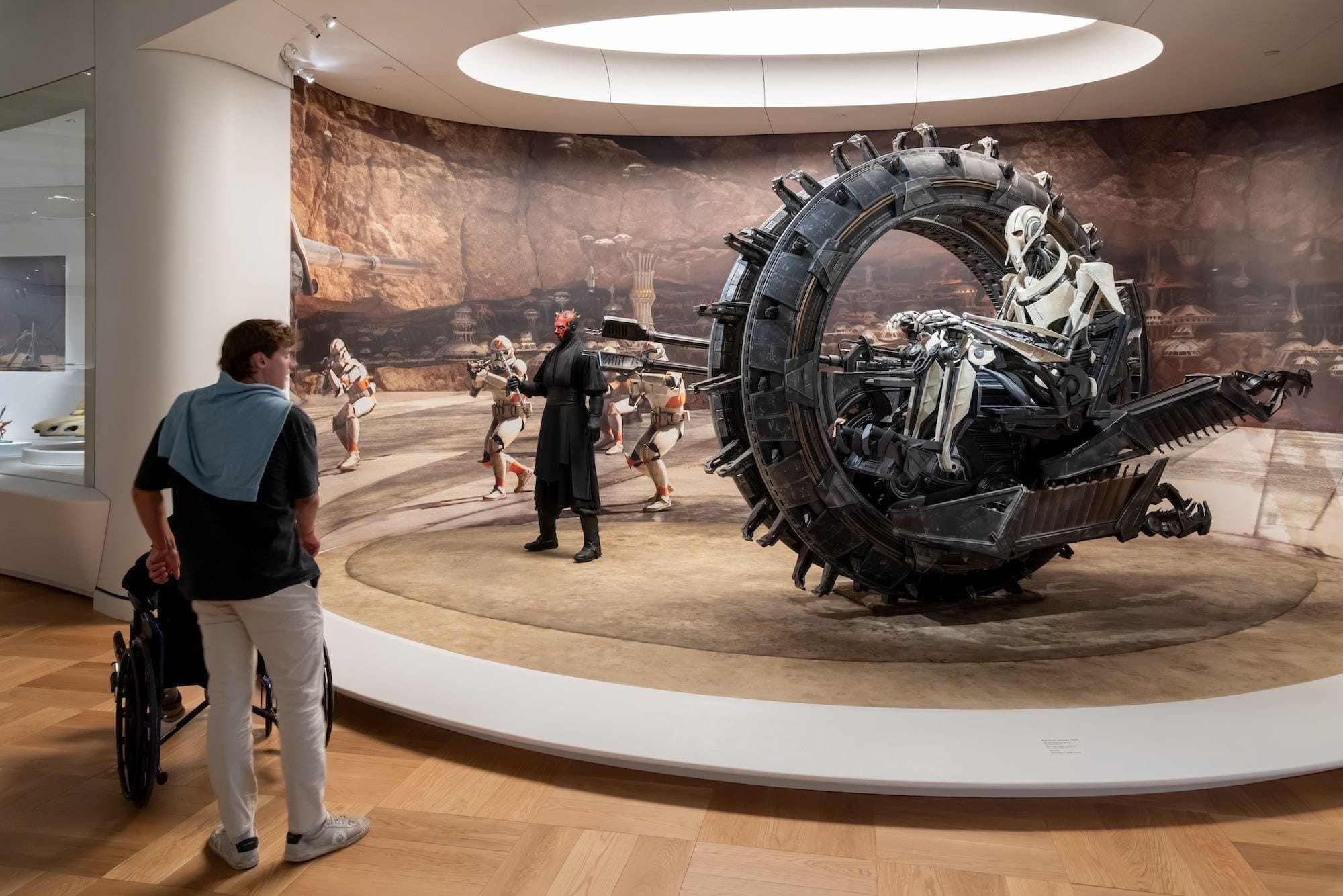 Galerie Star Wars du Lucas Museum of Narrative Art, avec la moto à roue du général Grievous et un visiteur