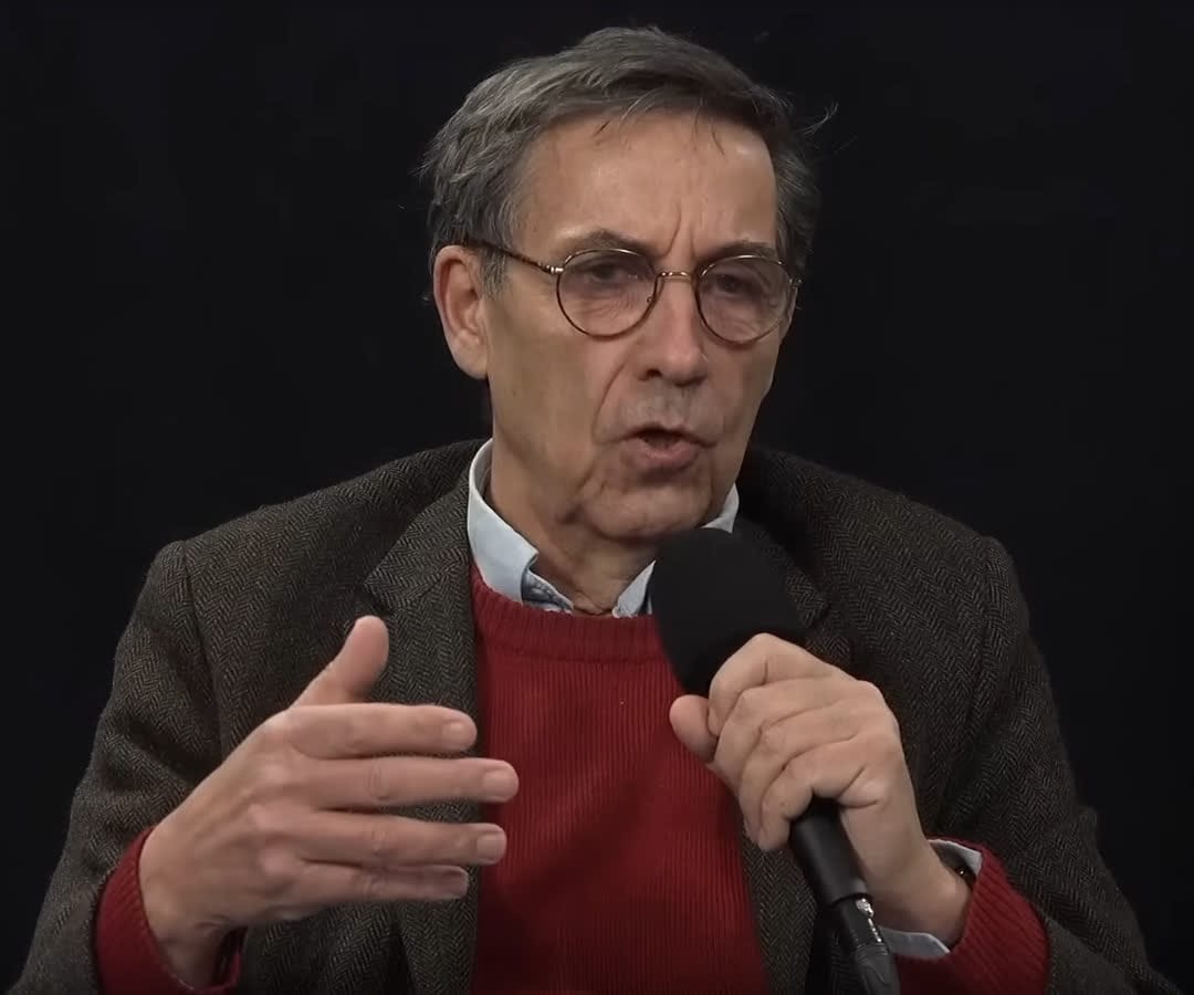 Emmanuel Todd, pull rouge et microphone à la main, en janvier 2024.
