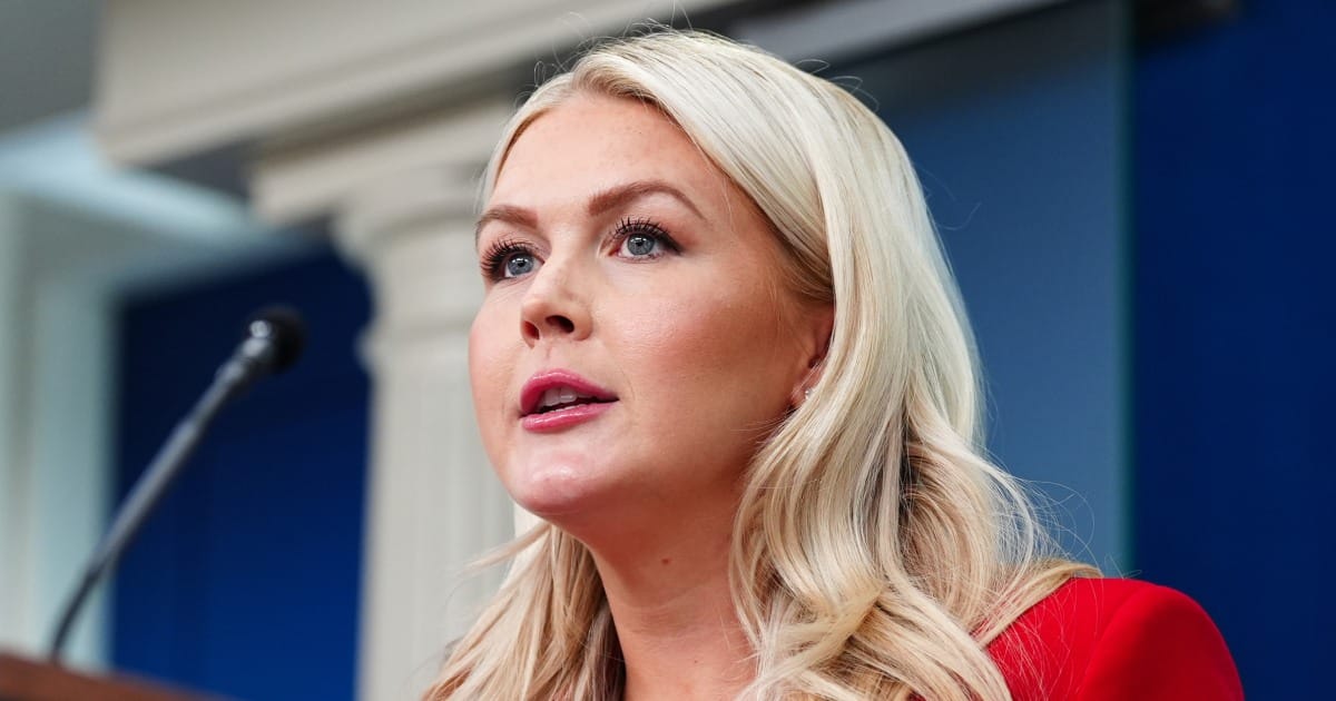 Karoline Leavitt parlant devant un micro au pupitre de la salle de presse de la Maison Blanche