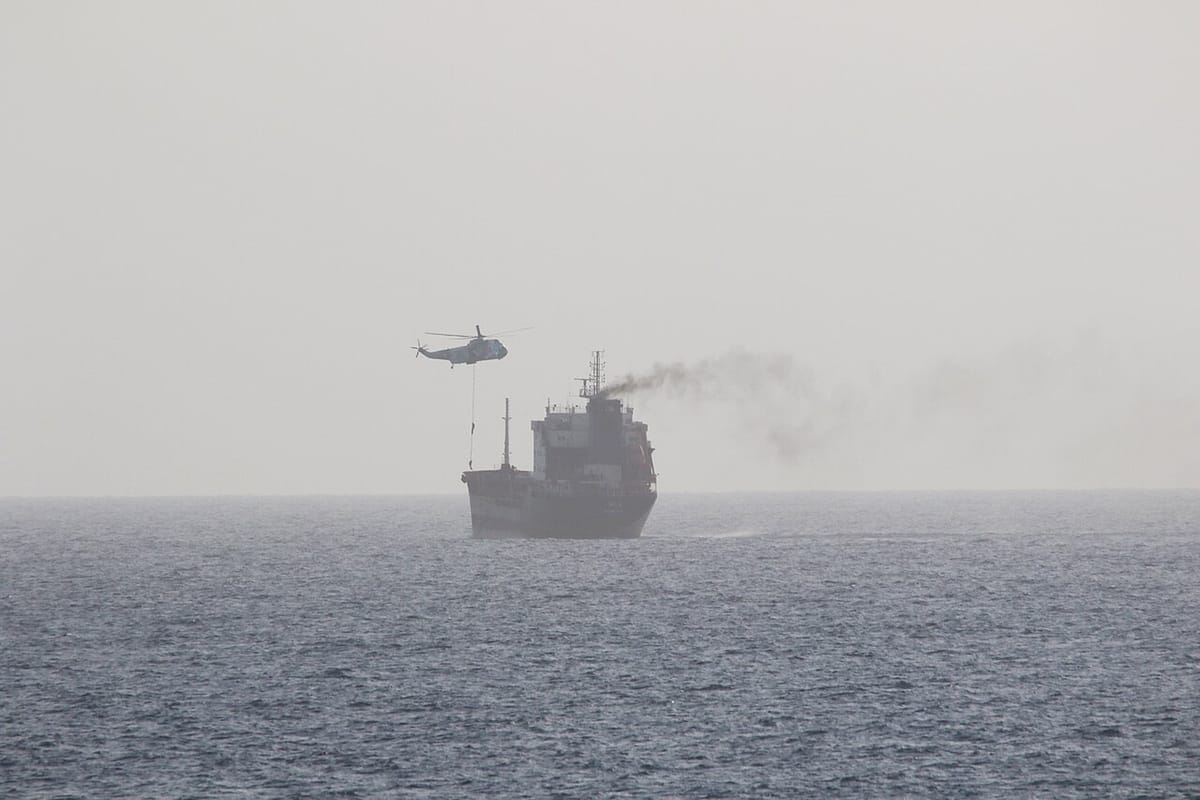 Un hélicoptère héliporte un commando au dessus d un navire marchand en pleine mer, dans la brume du Golfe
