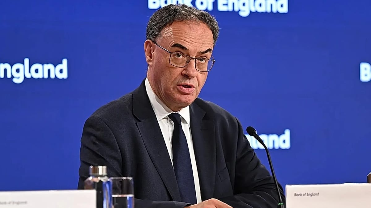 Andrew Bailey, gouverneur de la Banque d’Angleterre, en conférence de presse, parlant au micro devant un fond bleu répétant le logo Bank of England.