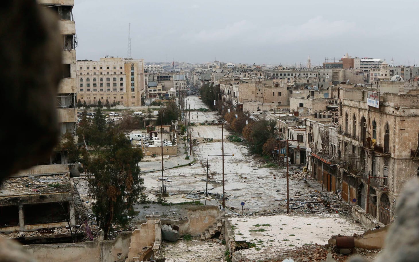 A general view shows damaged buildings along a deserted street and an area controlled by forces loyal to Syria's President Bashar Al-Assad, as seen from a rebel-controlled area at the Bab al-Nasr frontline in Aleppo February 10, 2015. REUTERS/Hosam Katan