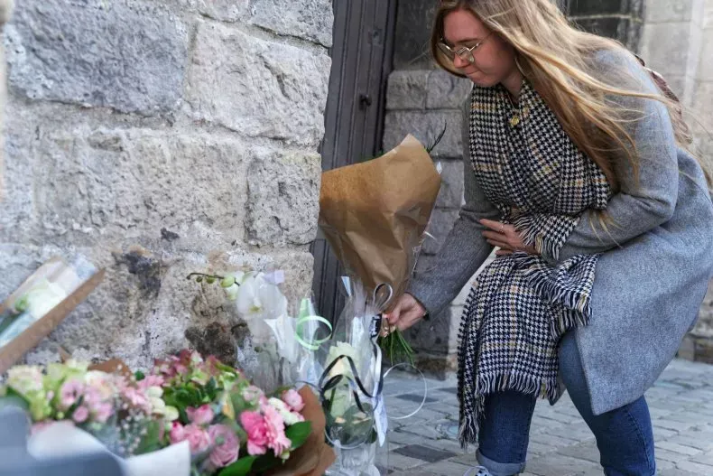 LILLERS, FRANCE - 24 OCTOBRE : Une jeune femme dépose des fleurs devant la collégiale "St Omer" avant les funérailles de Lola le 24 octobre 2022 à Lillers, France. SYLVAIN LEFÈVRE/GETTY IMAGES